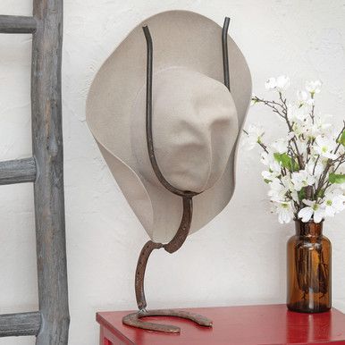 Exclusive Item - Add rugged western style to any room with this rustic metal cowboy hat stand. 8"W x 7"D x 21"H. Western Hat Store Display, Horseshoe Hat Rack, Cowboy Hat Display, Cowboy Hat Review Mirror, Welding Projects Hat Rack, Saddle Decor, Cowboy Hat Decor, Cowboy Living Room, Cowboy Couture