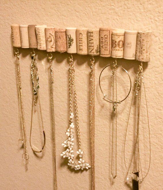 several necklaces are hanging on a wall with wine corks attached to the hooks