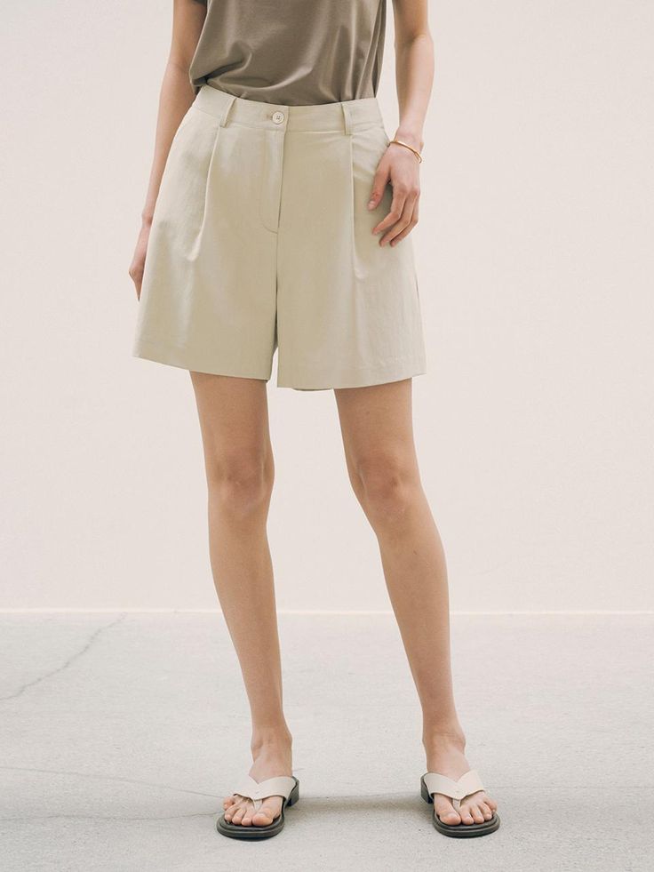 This is a refined and minimal pants by Siyazu that is made out of high quality and sturdy material. With classic mood of the design and feminine look, you can style it for your refined and casual daily outfit.- Single tuck detail- Comfortable and soft touch of fabric- Natural sea shell buttons- Clean logo embroidery detail High-waisted Khaki Shorts For Work, Chic High-waisted Shorts In Solid Color, Chic High-waisted Solid Color Shorts, Chic Neutral Cotton Shorts, Classic Short Pants In Solid Color, Elegant Solid Color Shorts For Workwear, Elegant Solid Color Shorts For Work, Classic Short Solid Pants, Elegant Shorts For Workwear