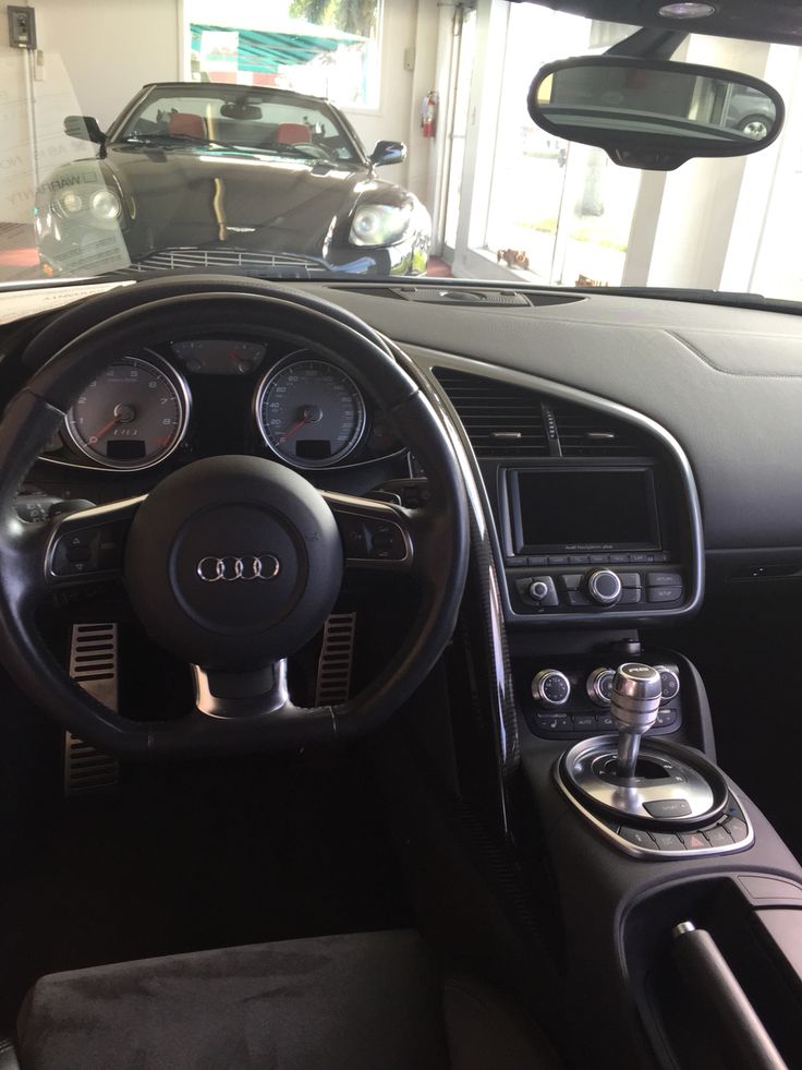 the interior of a car with steering wheel and dashboard