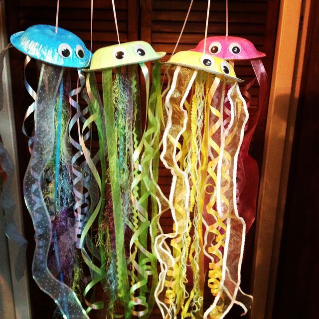 three jelly fish hanging from strings with eyes on them