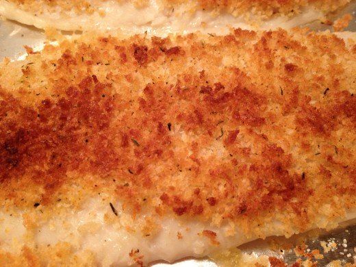 two pieces of fried fish sitting on top of a pan