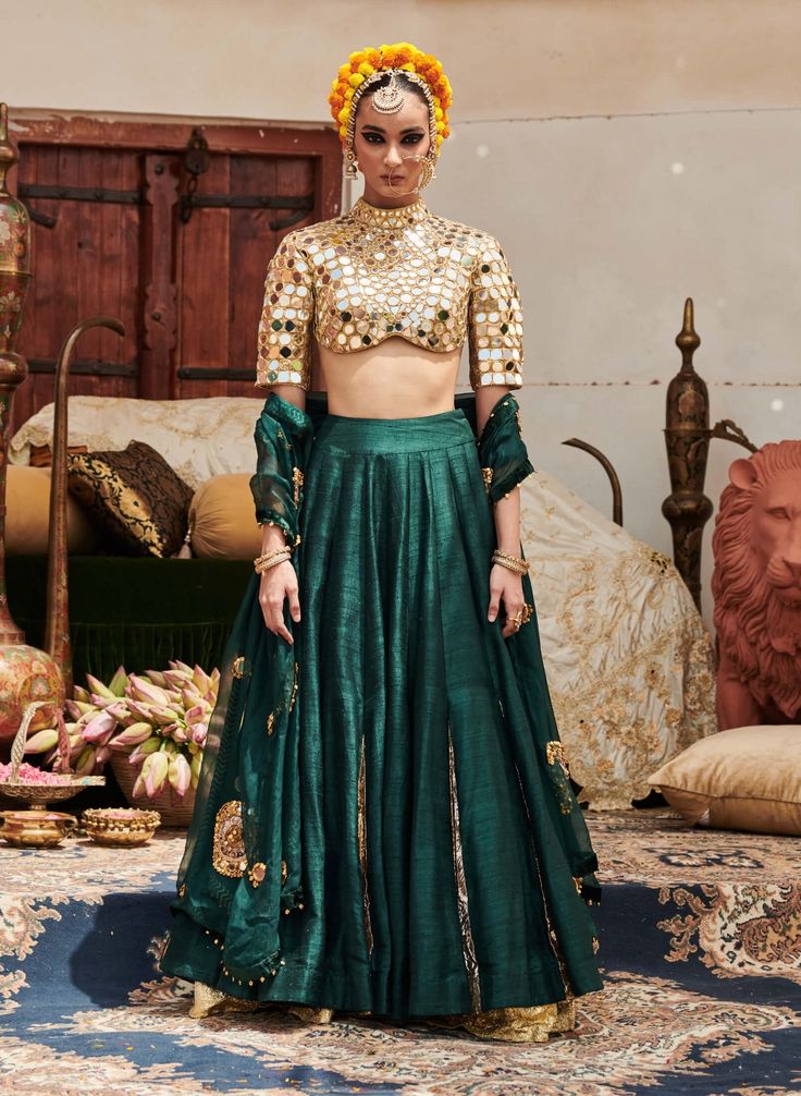 An exquisite creation, this lehenga in luxurious raw silk fabric is paired with a stylish zero neck matching blouse featuring three-fourth sleeves adorned with intricate mirror work. Complementing the outfit is a delicate organza dupatta (Optional: green or blue dupatta) that adds a touch of elegance and grace. Perfect for special occasions, this ensemble beautifully balances tradition and modern sophistication. Green Chanderi Dress For Reception, Green Saree Set For Reception, Green Chanderi Gown For Reception, Semi-stitched Organza Palazzo Set With Cutdana, Tissue Silk Sets With Gota Work For Reception, Festive Green Art Silk Palazzo Set, Reception Sets With Gota Work In Tissue Silk, Reception Sets In Tissue Silk With Gota Work, Green Silk Anarkali Set For Reception