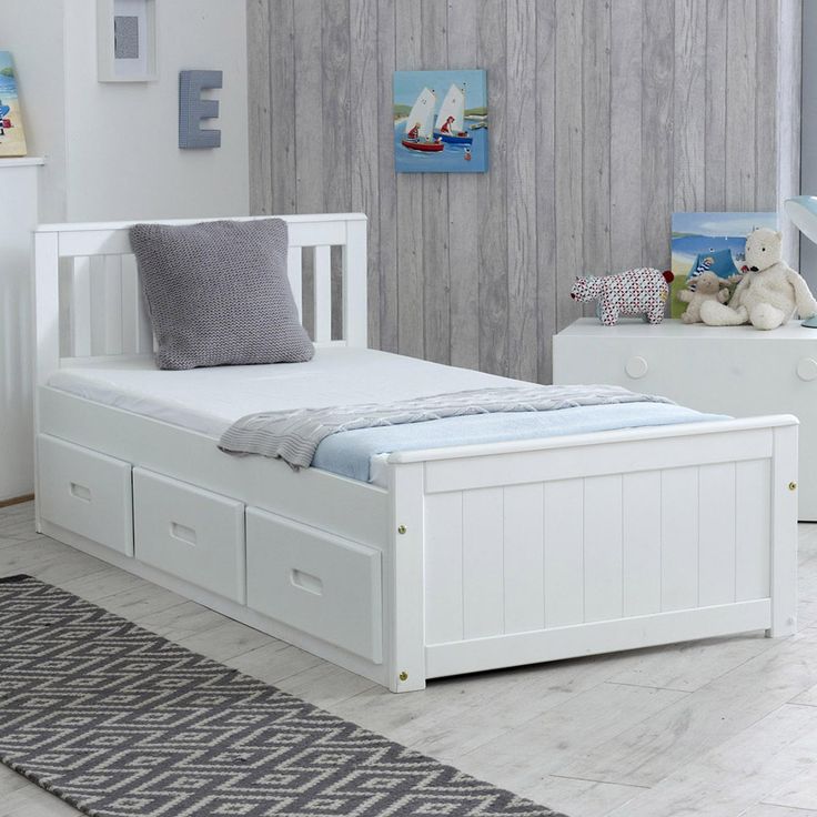 a child's bedroom with white furniture and decor