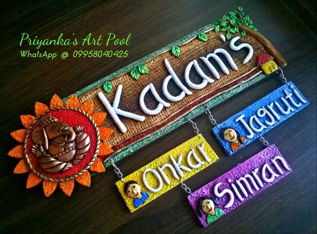 three colorful nameplates hanging from a wooden table with the word kaladan's written in different languages