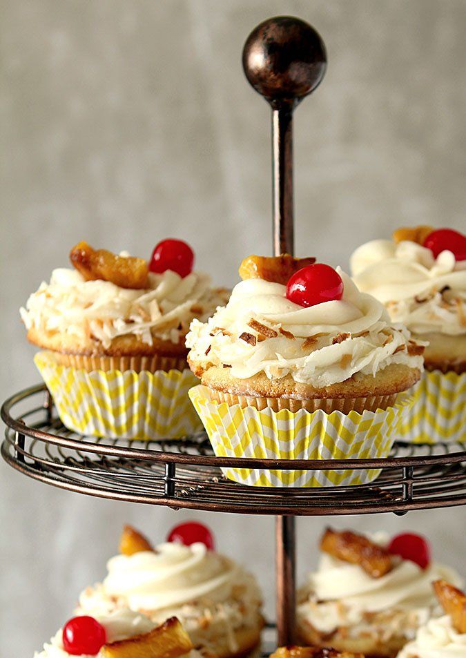 cupcakes with white frosting and cherries on top