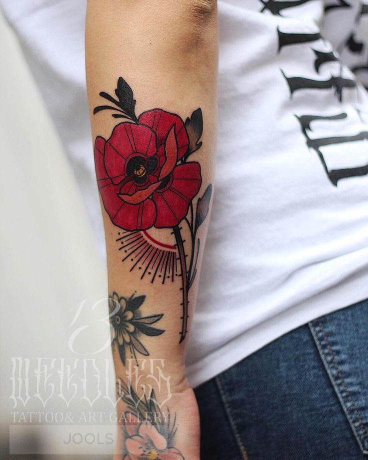 a woman with a red flower tattoo on her arm