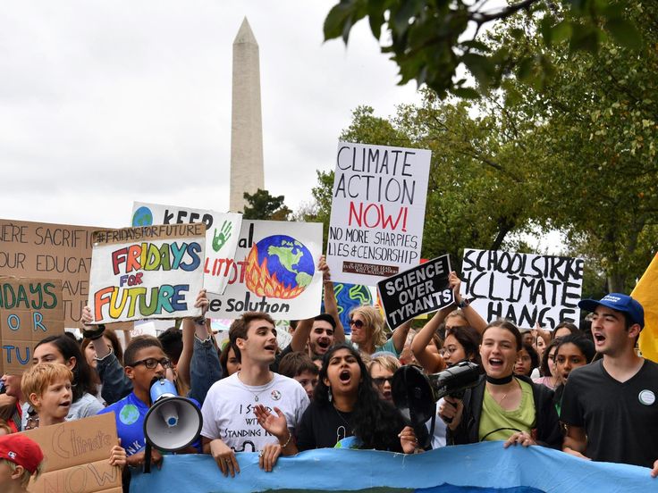 a group of people holding signs and megaphones in front of the washington monument,