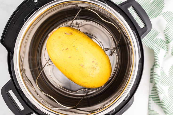 a yellow potato sitting in an instant pot on top of a white and green towel