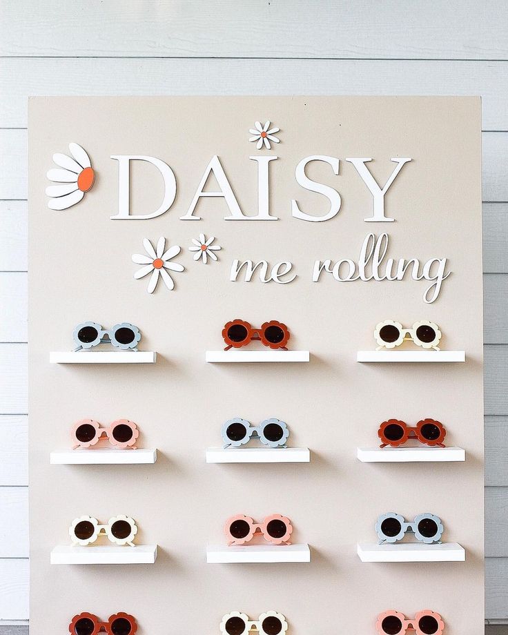 a sign that says daisy me rolling with some sunglasses on top of the display shelves