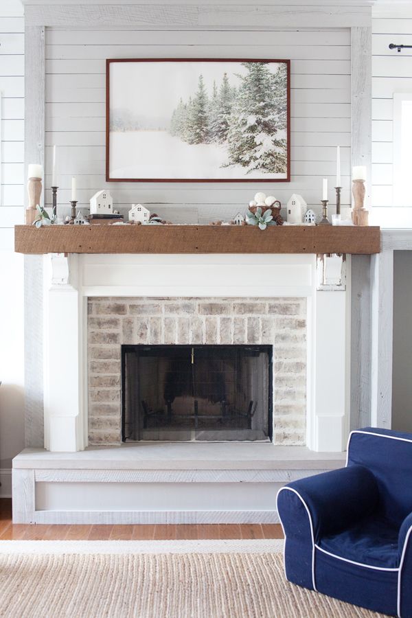 a living room with a white fireplace and blue chair