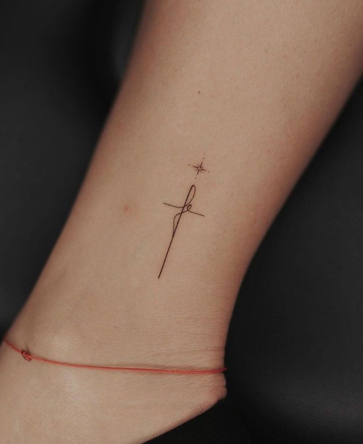 a small tattoo on the ankle of a woman's foot with a cross in it