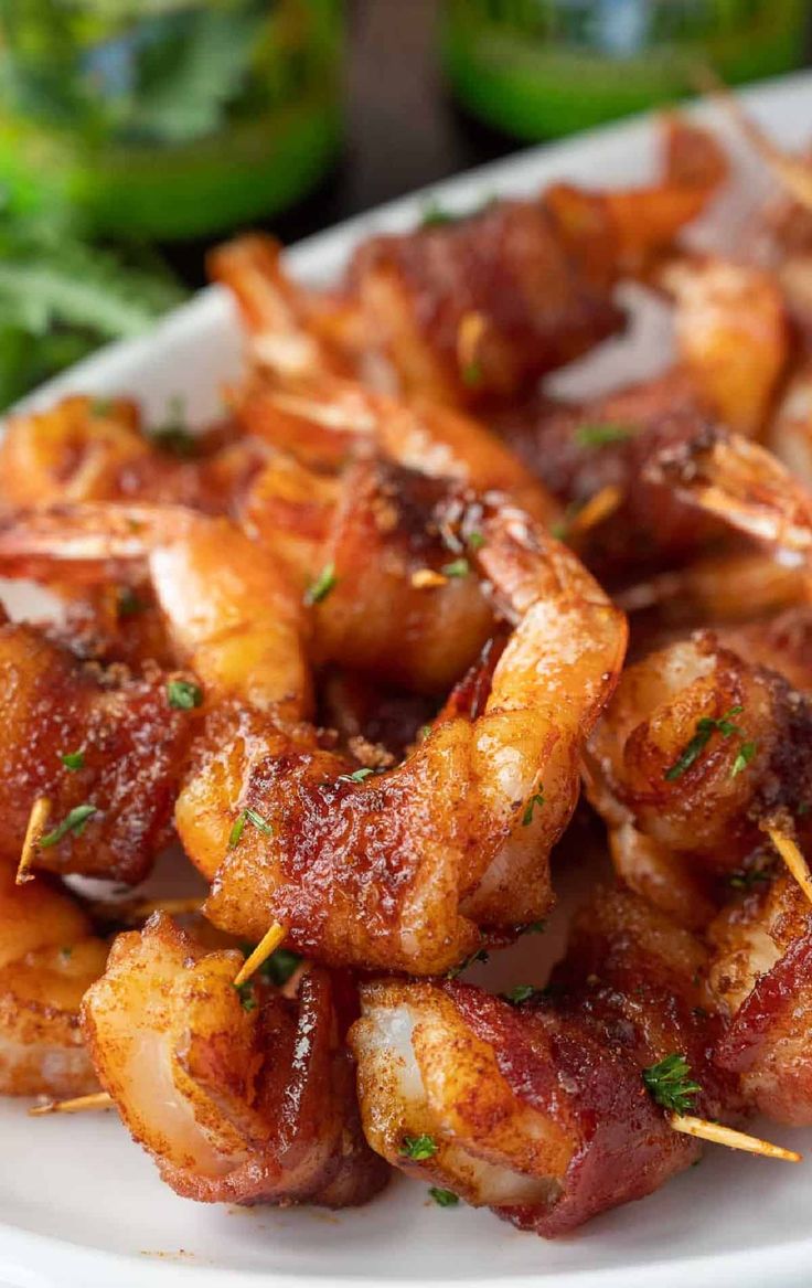 shrimp skewers on a white plate with parsley