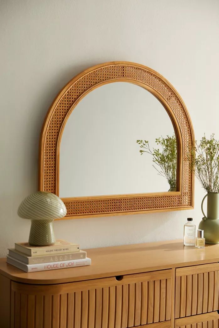 a wooden dresser with a mirror and vase on top