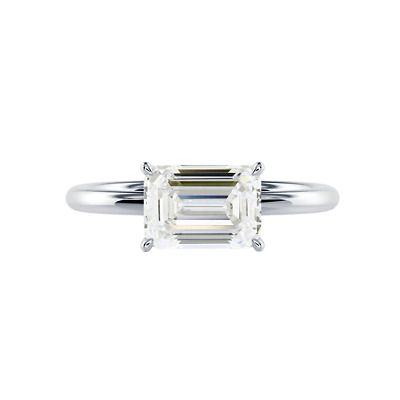 an emerald cut diamond engagement ring on a white background