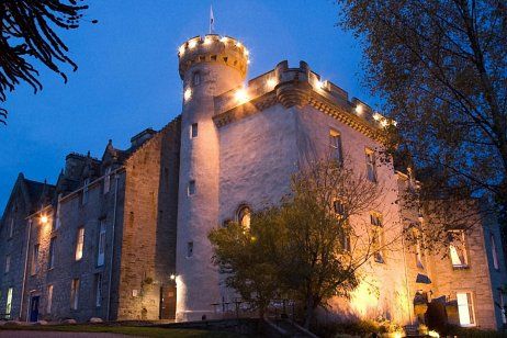 a castle like building lit up at night with lights on the top and bottom floors