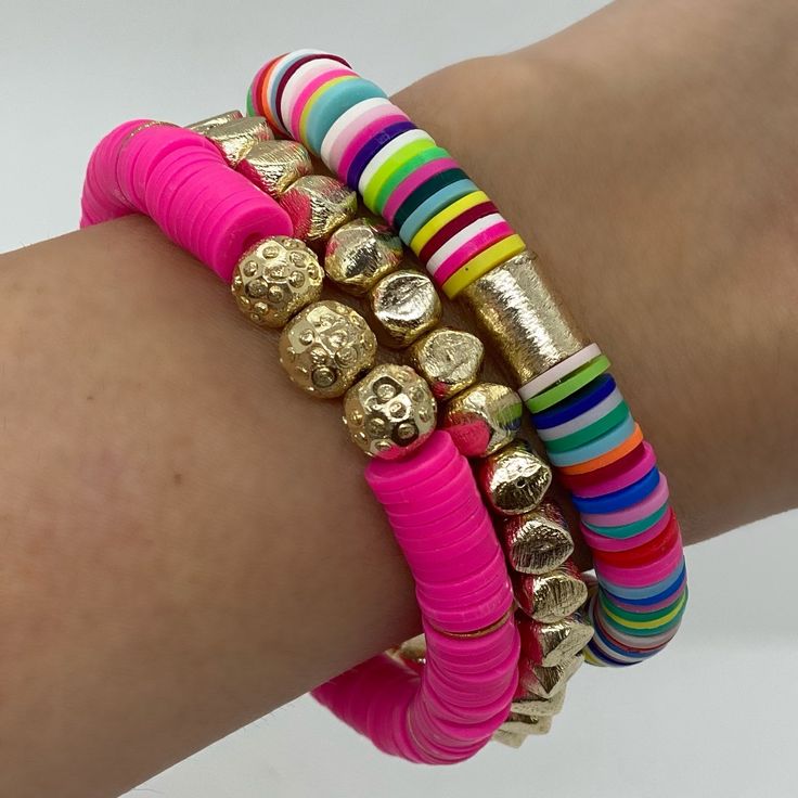 a woman's arm with several bracelets on it and gold coins in the middle