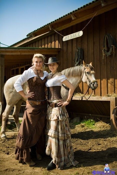 two women standing next to each other in front of a horse