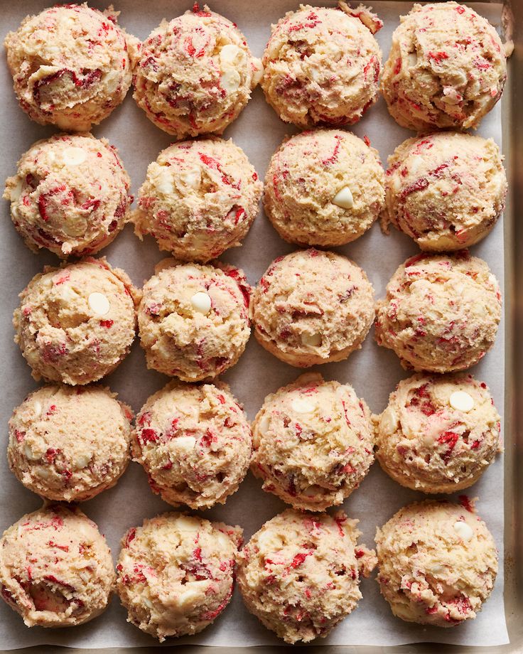 freshly baked strawberry muffins on a baking sheet lined with parchment paper and ready to be eaten