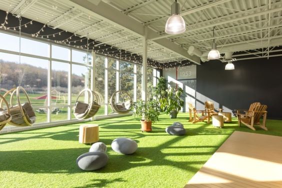 an indoor area with hammock chairs and artificial grass