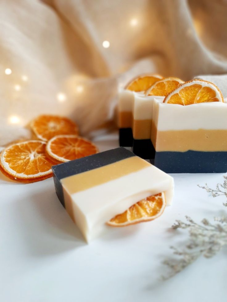 soap bars with orange slices on them sitting next to some dried lavender and an orange slice