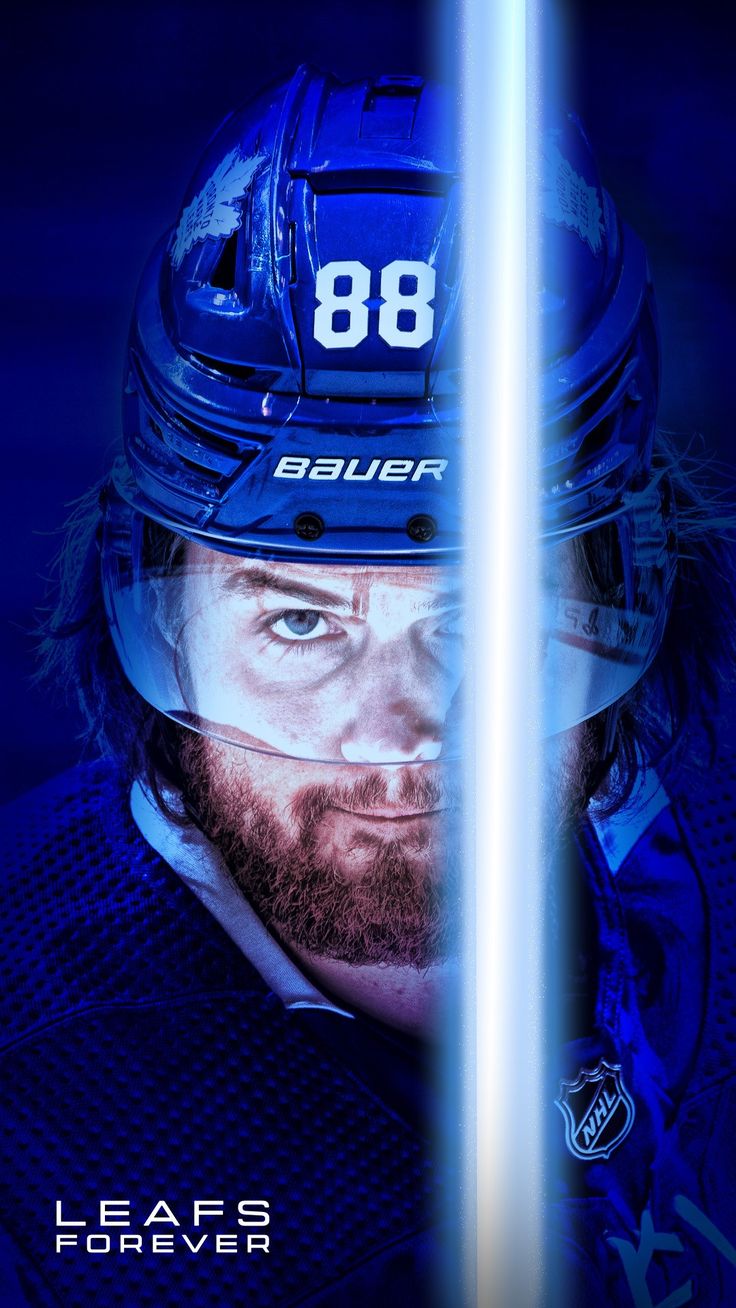 the hockey player is wearing a blue uniform and holding a light saber in his hand