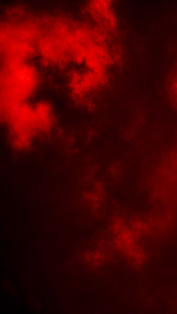 red clouds in the dark sky with a plane flying by on it's side