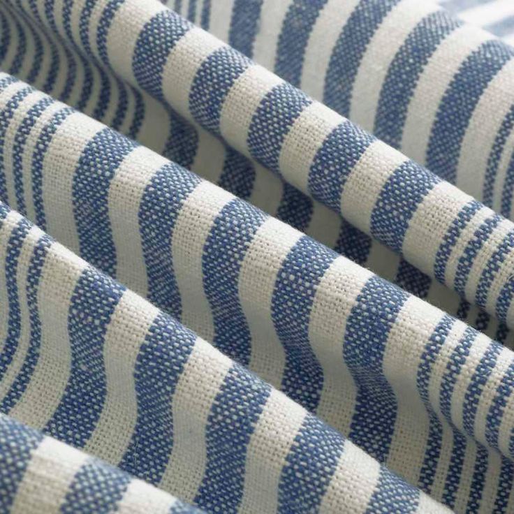 blue and white striped fabric is shown in close up view, with vertical stripes on it