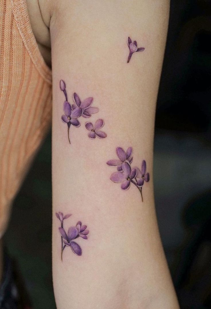 a woman's arm with purple flowers on it