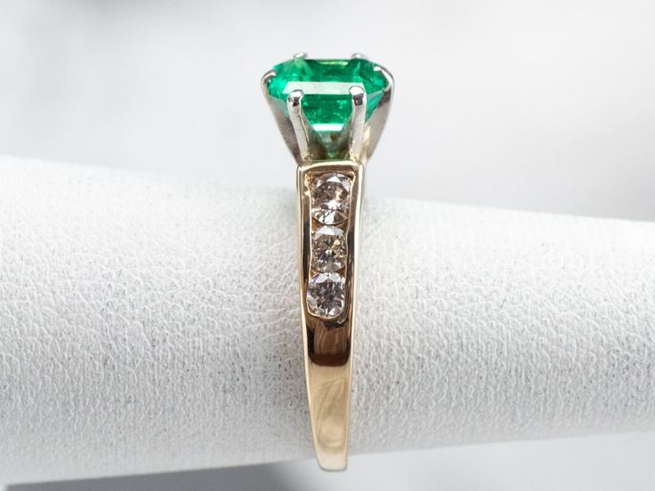 This emerald and diamond ring is classic, yet dazzling! The emerald is hypnotic and dreamy, with an iconic green hue that can't help but draw your eye. Bright and sparkling diamonds cascade down the shoulders of the ring, creating a gorgeous play of light. Metal: Platinum (Head), 14K Yellow Gold Gem: Emerald .94 Carats Gem Measurements: 4.6 x 6.4 mm, Emerald Cut Accents: 6 Diamonds totaling .42 Carats, SI in Clarity, H in Color Ring Size: 4.25 Marks: "88 14K" Stamped on the inside band Green Emerald Diamond Ring With Accents, Green Emerald Ring With Diamond Accents, Asscher Cut Emerald Ring With Diamond Accents, Emerald Green Diamond Ring With Brilliant Cut, Green Princess Cut Diamond Ring In Fine Jewelry Style, Fine Jewelry Green Princess Cut Diamond Ring, Emerald Cut Green Diamond Ring With Diamond Accents, Green Princess Cut Diamond Ring Fine Jewelry, Emerald Cut Green Diamond Ring With Accents