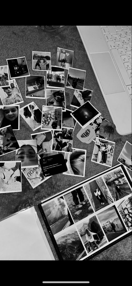 black and white photograph of various photographs on the floor next to a laptop computer with text overlay