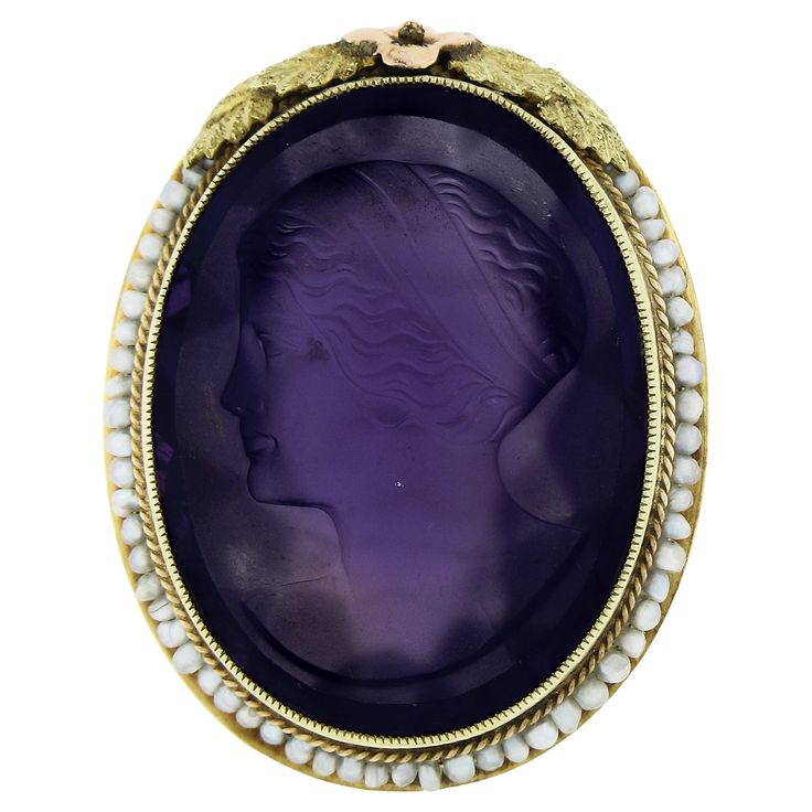 This rare antique art deco ring was crafted from solid 14k yellow & green gold with rose gold accents. It features a detailed carved amethyst left facing cameo neatly bezel set at the center of the ring. The outstanding carving shows a detailed portrait of a woman and is absolutely wonderfully framed by Milgrain, twisted wire & seed pearls. The ring is further engraved with delicate scroll work on the side shoulders and is decorated with a daisy flower & leaves at the top of the frame. This is a Art Nouveau Oval Cameo Jewelry, Art Nouveau Yellow Gold Intaglio Jewelry, Antique Gemstone Jewelry For Memorial, Collectible Art Deco Cameo Jewelry, Antique Yellow Gold Amethyst Ring, Antique Amethyst Ring With Filigree, Art Deco Cameo Jewelry For Anniversary, Art Nouveau Oval Cabochon Jewelry, Art Nouveau Oval Gemstone Jewelry