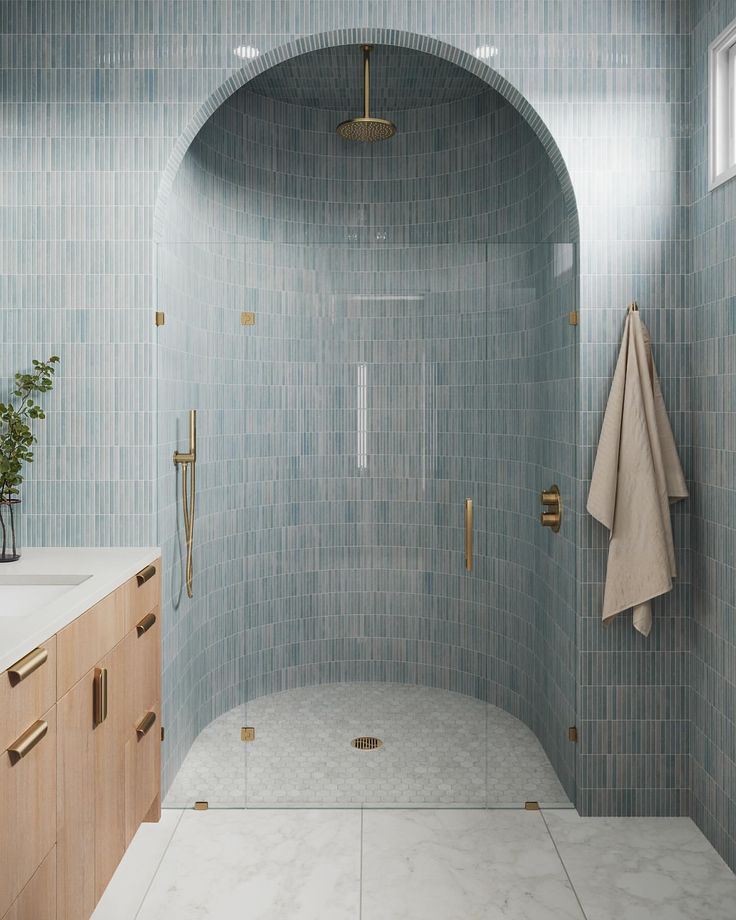 a bathroom with blue tile and gold fixtures