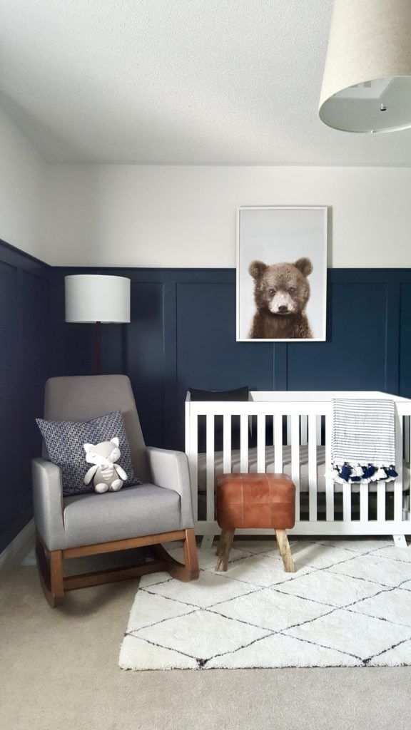 a baby's room with blue and white walls, a teddy bear on the wall