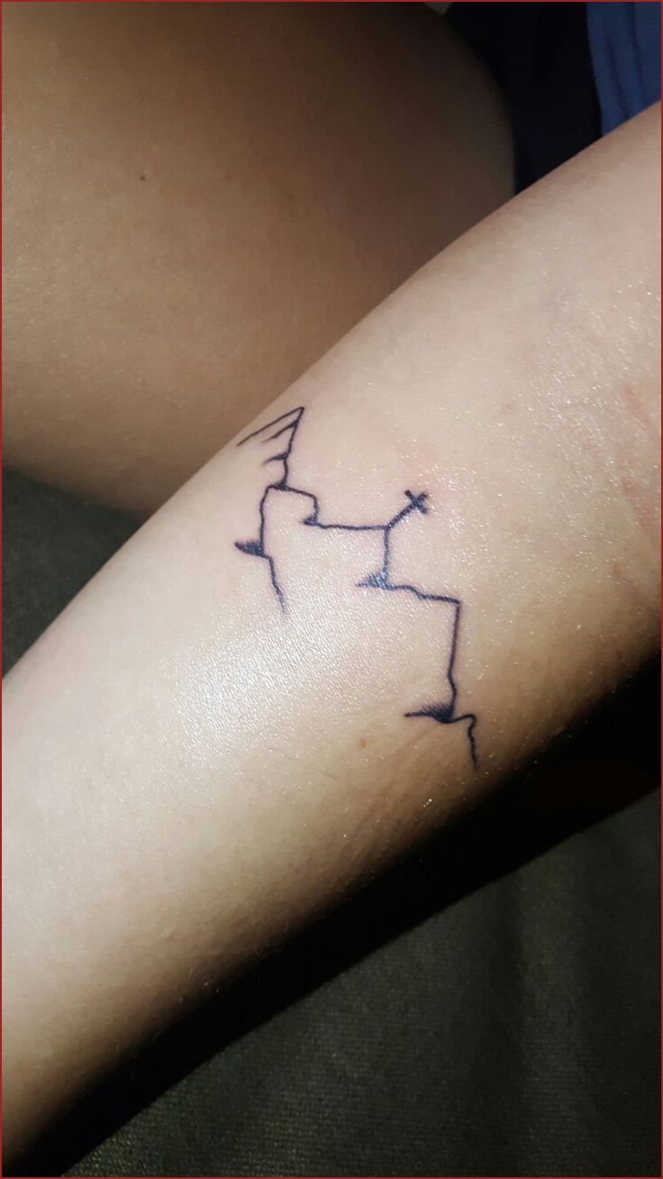 a person with a tattoo on their arm that has arrows in the shape of an arrow