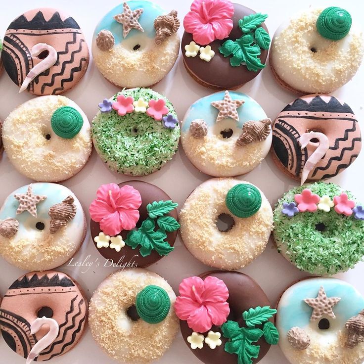 there are many decorated doughnuts on the table together, including one with flowers and an elephant