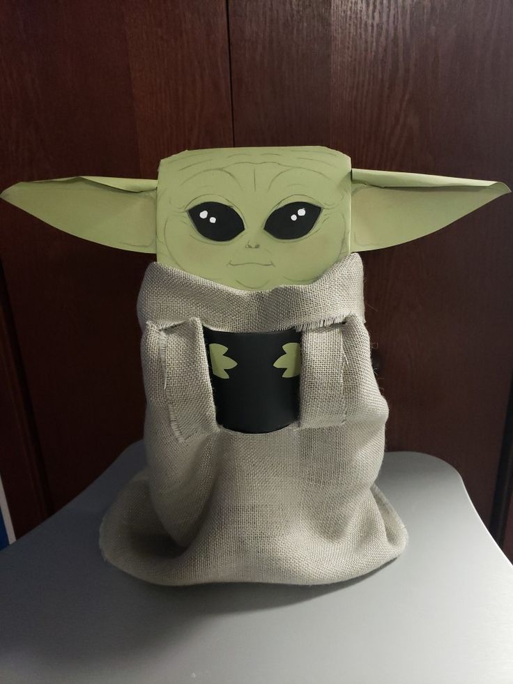 the baby yoda doll is holding a book