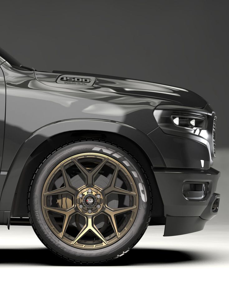 the front end of a black truck with gold rims