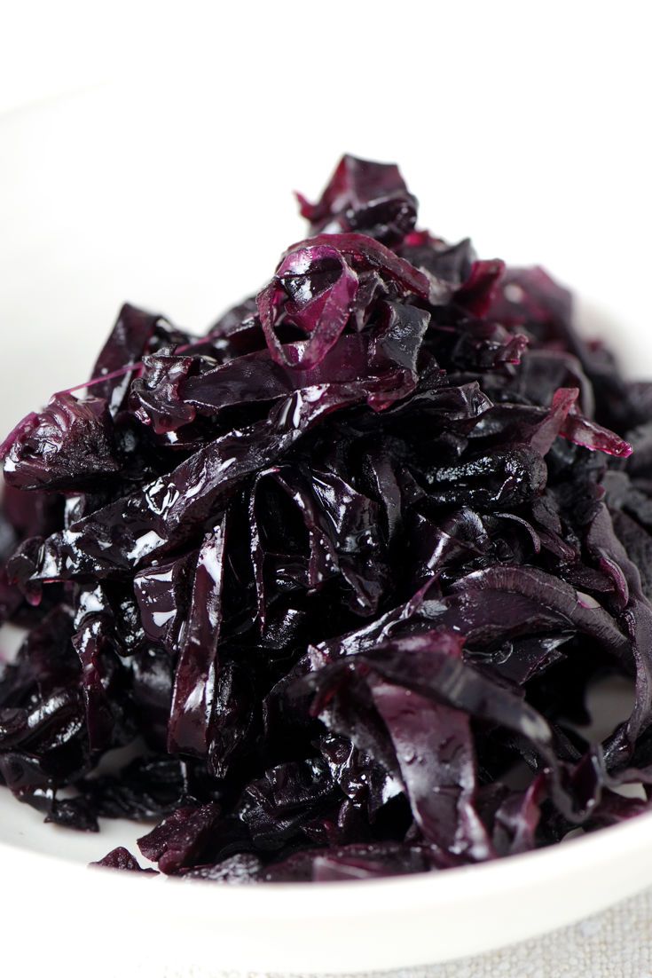 a white bowl filled with red cabbage on top of a table