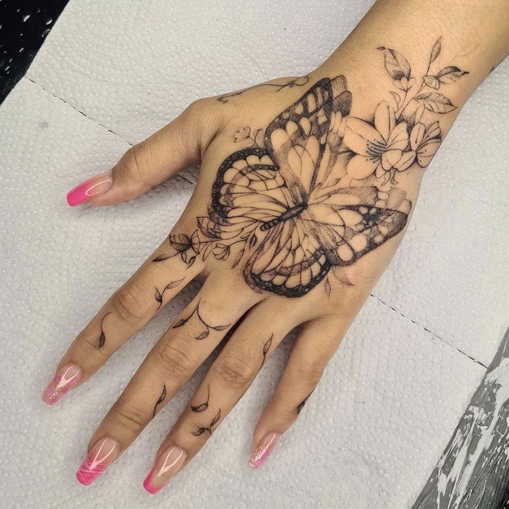 a woman's hand with a butterfly tattoo on it