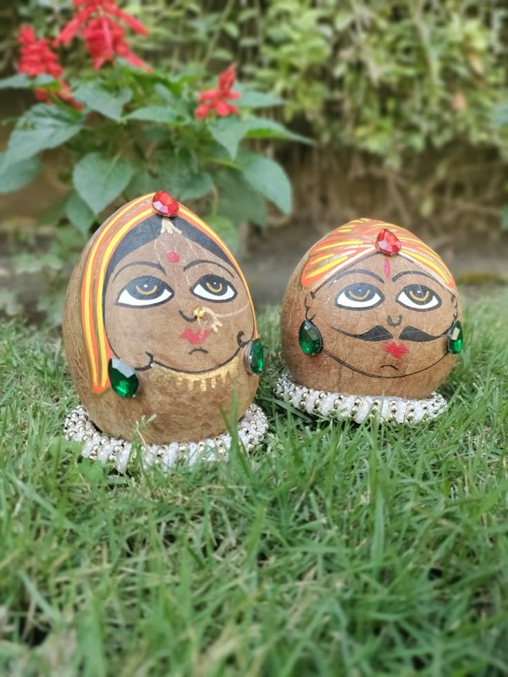 two small wooden dolls sitting in the grass