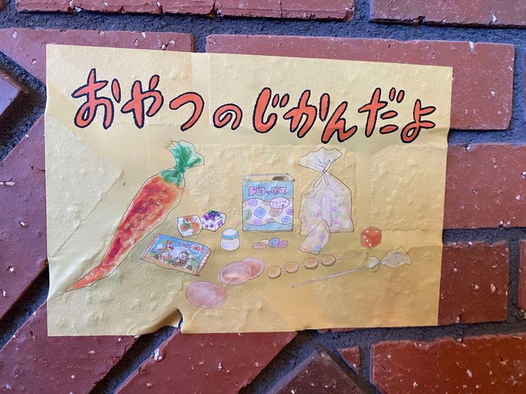 a sign posted on the side of a brick wall that says hello kitty and carrots