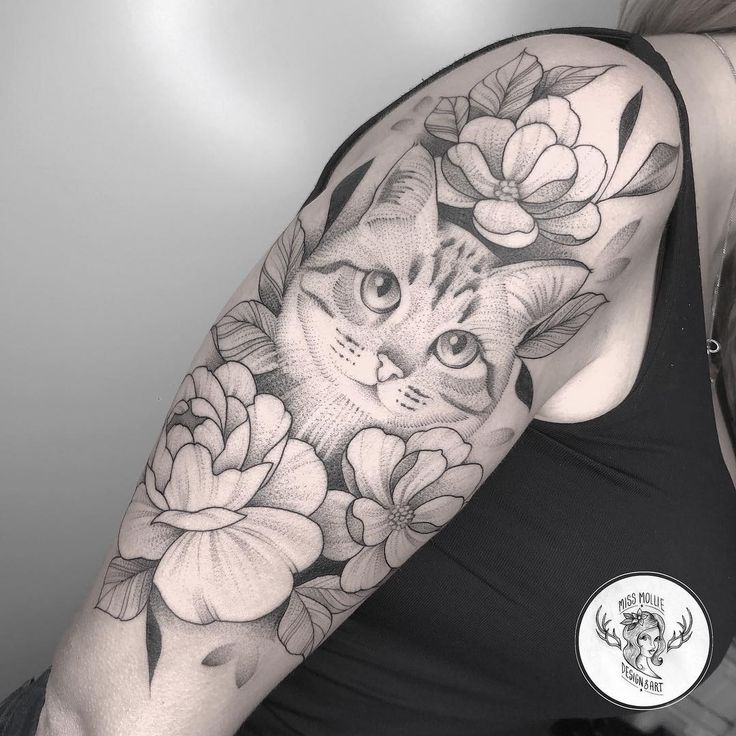 a woman with a cat and flowers tattoo on her arm