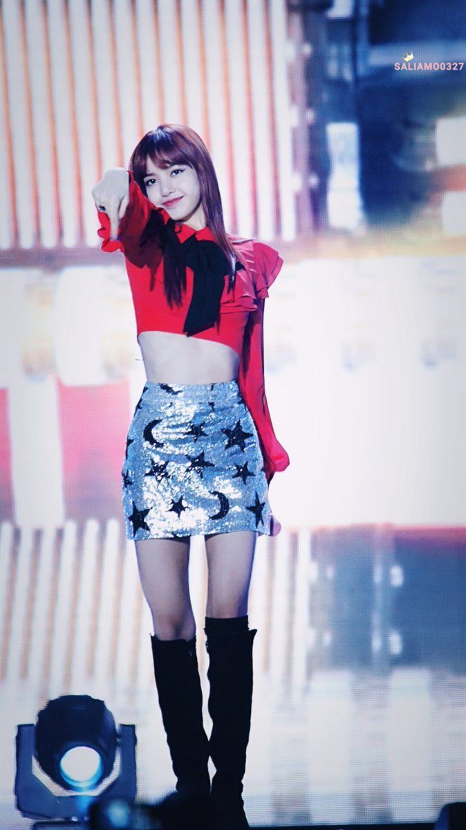 a girl in a short skirt and boots on stage with her hands behind her head