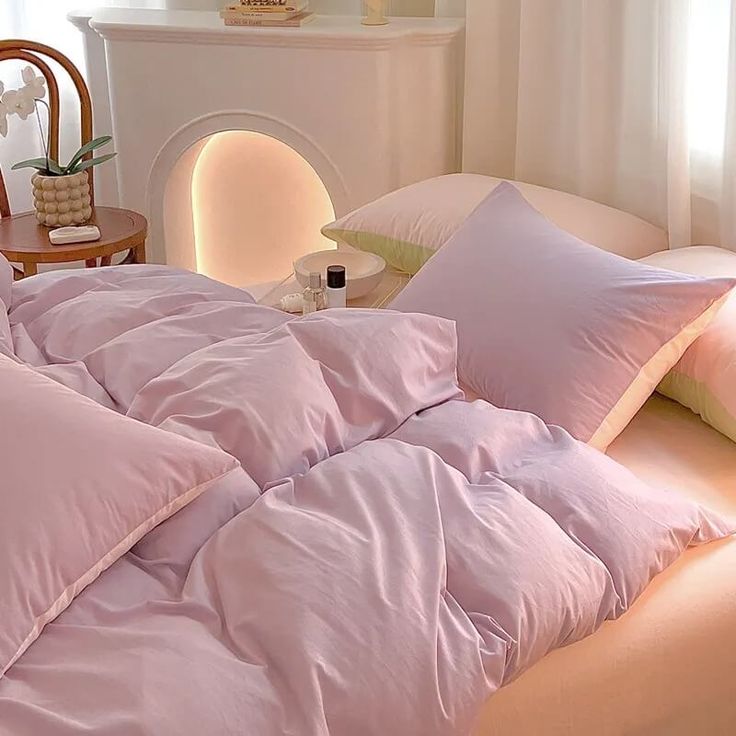 an unmade bed with pink sheets and pillows