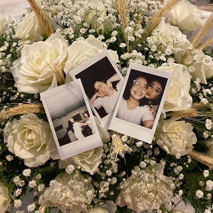 three polaroid frames are placed on top of a bouquet of flowers and baby's breath