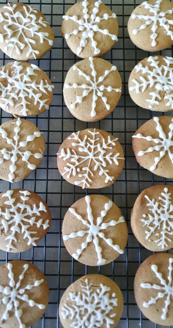 twelve cookies with white icing on a cooling rack, ready to be baked in the oven