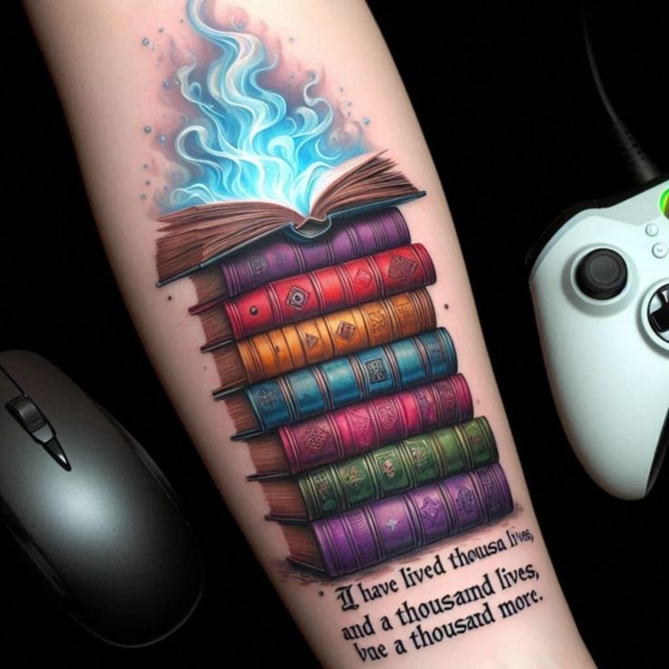 a book tattoo on the arm with a game controller next to it