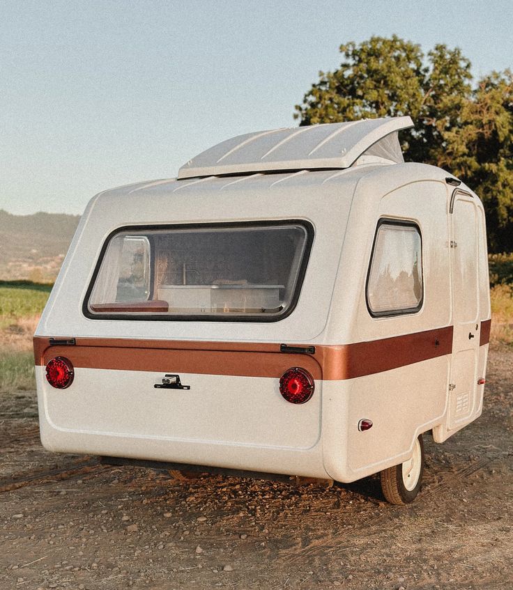 an old camper is parked in the dirt