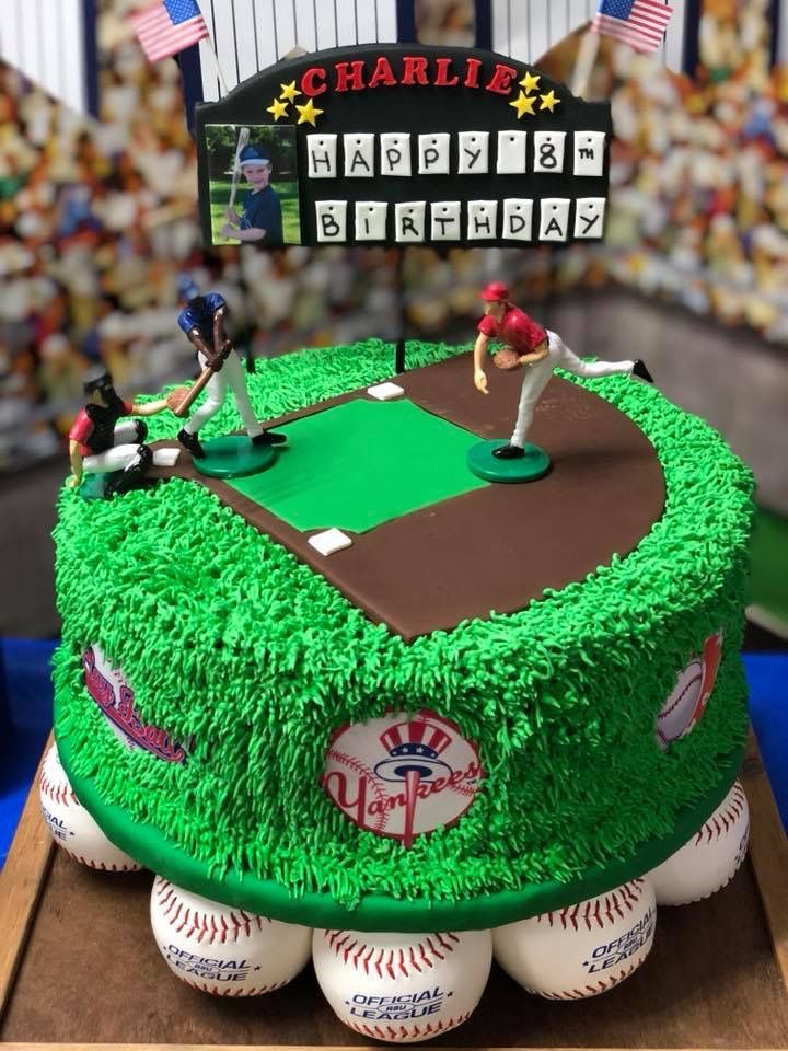 a cake that is shaped to look like a baseball field with players on it and the scoreboard in the background